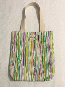 This Nola Stripes small tote is a party in your purse! Show 'em you know how to have a good time with the iconic Mardi Gras colors of purple, green, and yellow. Plus this sustainable tote is 100% cotton, so you can party on with a clear conscience.   All the materials are 100% cotton making it a sustainable item. This cute handmade tote bag is around 15 inches wide and 18 inches long with a 4 inch bottom.