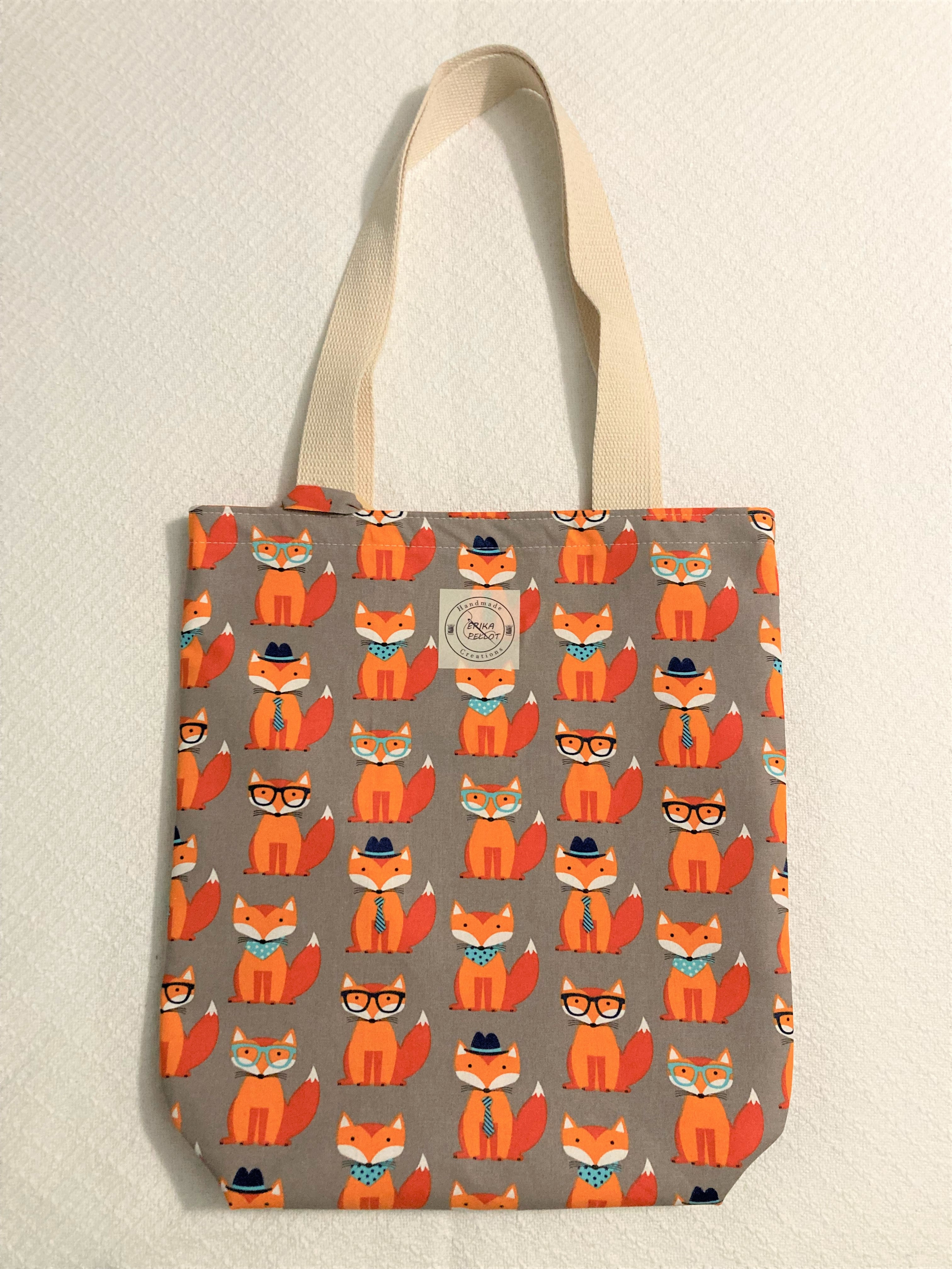 Be a foxy mama with the stylish Smart Fox small tote! Constructed from 100% cotton with an adorable fox print, this lined tote bag has the look and feel you'll love. Stylish and tote-lly practical - you can't go wrong. (And it's definitely not too foxy!)   All the materials are 100% cotton making it a sustainable item. This cute handmade tote bag is around 15 inches wide and 18 inches long with a 4 inch bottom.