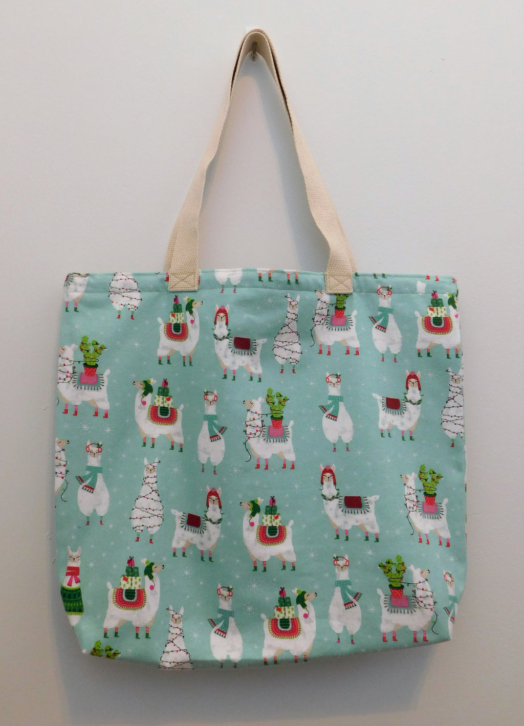 Llama, llama, llama!!! Gotta have fun with llamas! This fun tote has cute llamas in holiday hats and are wrapped in Christmas lights in a teal background. The fabric is Super Snuggle, super soft and 100% cotton, along with muslin lining, trim, and thread. To care for your tote bag machine wash gentle cold, non-chlorine bleach or fab softener, tumble dry low and cool iron.