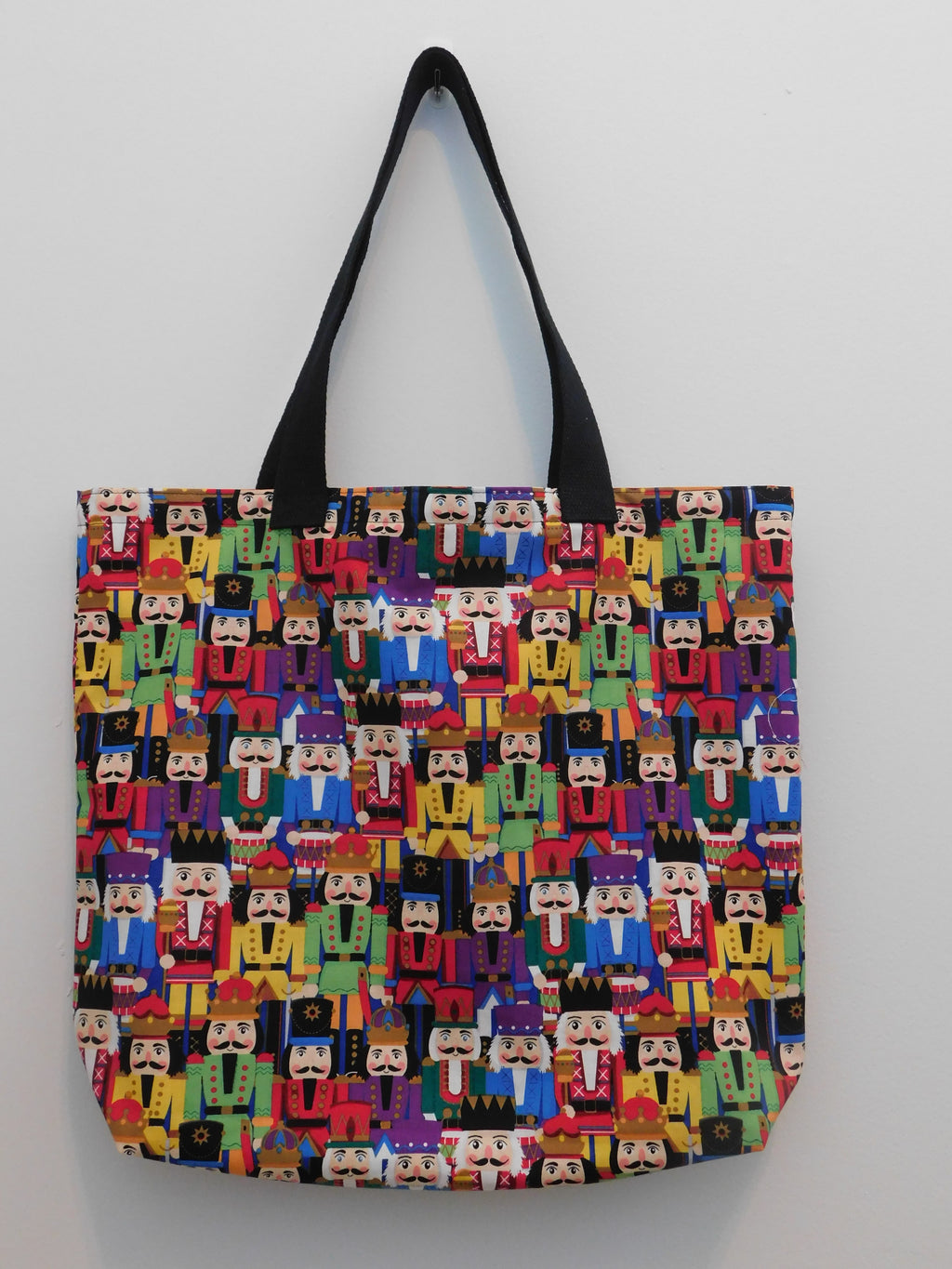 Nutcracker is my favorite tote! This handmade tote bag is covered in colorful Nutcrackers. Perfect to care around during the holiday season. Minimize the use of plastic and use this tote to go shopping, carry books, use it travel or gift it to someone who loves the holidays! All materials are 100% cotton, from the fabric, the muslin lining, thread, and trim. Machine wash warm, tumble dry, remove promptly, do not bleach. Measurements are around 16in x 19in x 4in.