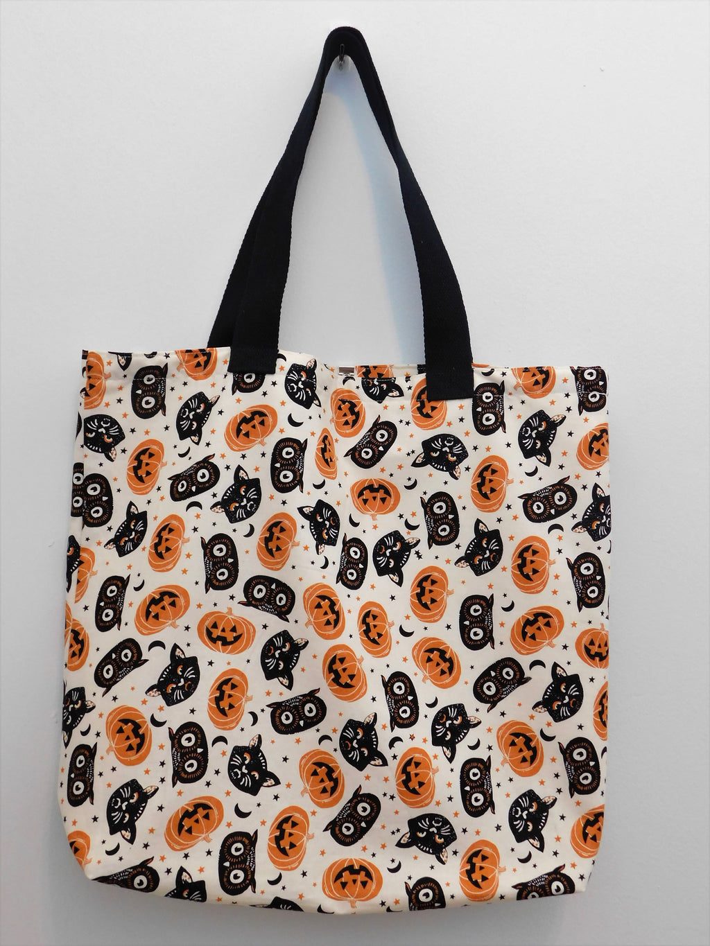 Handmade Tote bag, Tossed Cat Head Ivory, pumpkins, black cats and black owl heads fabric. Lined with muslin fabric, 100% cotton, machine wash gentle cold, non chlorine bleach, tumble dry low, cool iron. Measurements are around 16in, 18 1/2in, 4in.