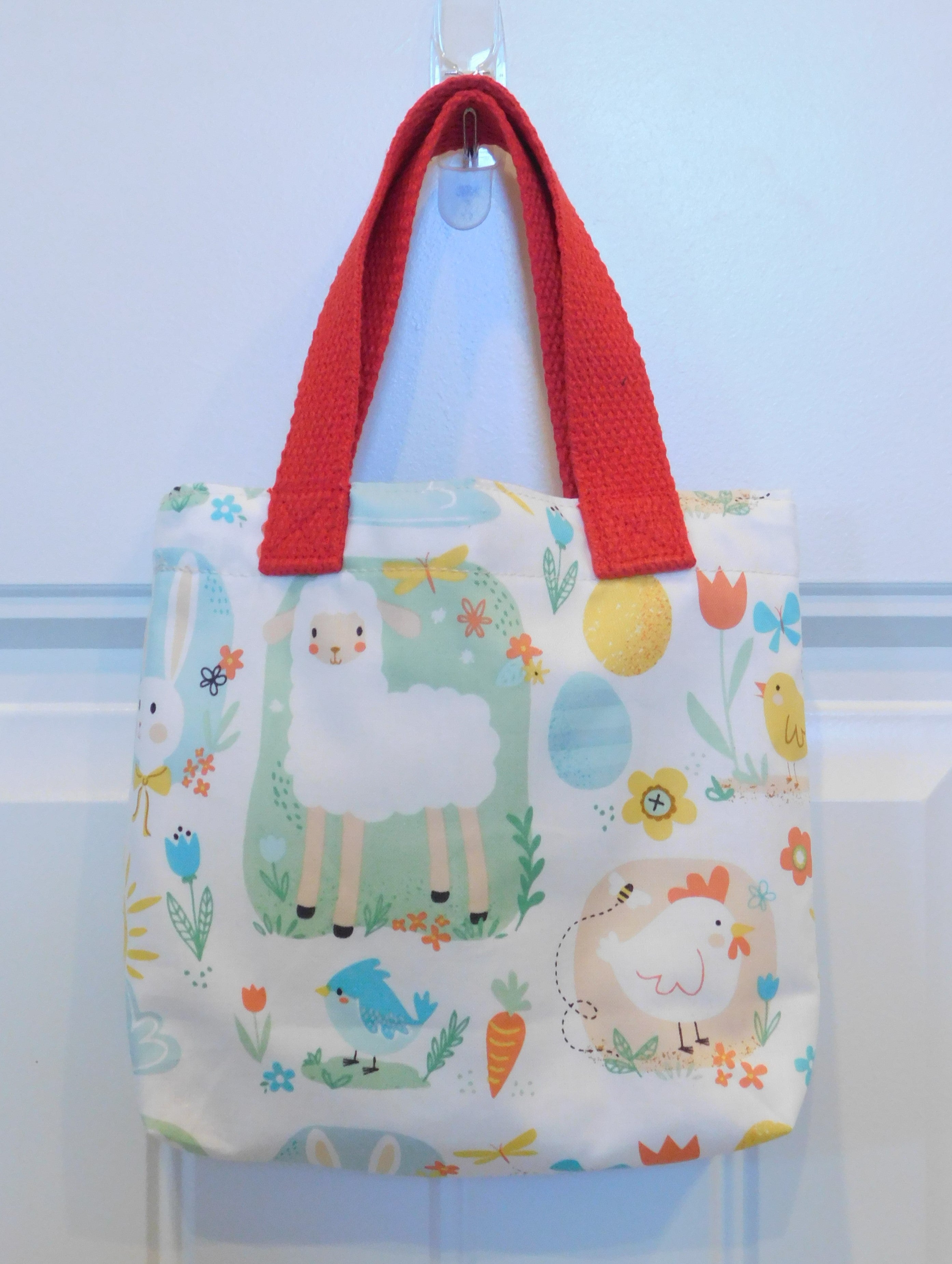 Pure cuteness! This mini tote has white sheep, chickens, blue birds, yellow and blue Easter eggs, bunnies, carrots, bees and butterflies. This beautiful handmade mini tote is perfect for your little one to style. They are lined and all the materials from fabric, trim, muslin and thread are 100% cotton.  To care for your mini tote machine wash warm, tumble dry, remove promptly, do not bleach. The measurements are 9in x 7in x 2in.