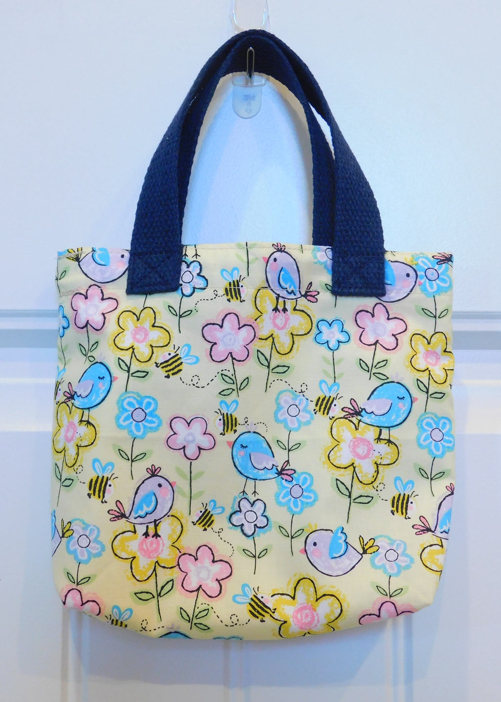 Chicks everywhere! Chicks galore in a background of yellow pastels covered in flowers. This beautiful handmade mini tote is perfect for your little one to style. They are lined and all the materials from fabric, trim, muslin and thread are 100% cotton. To care for your mini tote machine wash warm, tumble dry, remove promptly, do not bleach. The measurements are 9in x 7in x 2in.