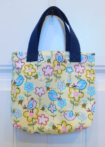 Chicks everywhere! Chicks galore in a background of yellow pastels covered in flowers. This beautiful handmade mini tote is perfect for your little one to style. They are lined and all the materials from fabric, trim, muslin and thread are 100% cotton. To care for your mini tote machine wash warm, tumble dry, remove promptly, do not bleach. The measurements are 9in x 7in x 2in.