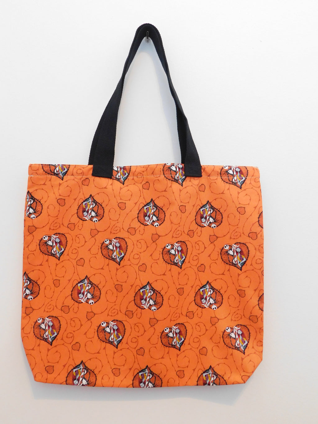 Jack and Sally for Halloween! This handmade orange tote bag has Jack Skellington and Sally inside hearts and orange background. The fabric, muslin lining and thread are all 100% cotton. Machine wash gentle cold, non chlorine bleach, tumble dry low, warm iron. Measurements are around 18in x 16in x 3in.