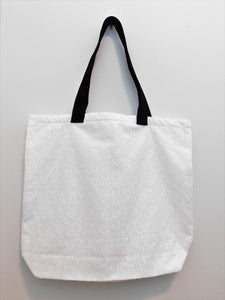 Elegance! This white floral eyelet handmade tote bag is perfect for spring. Fabric, muslin lining, black trim and thread are all 100% cotton. Machine wash cold, delicate cycle, tumble dry low. Measurements are around 19in x 16in x 4in.