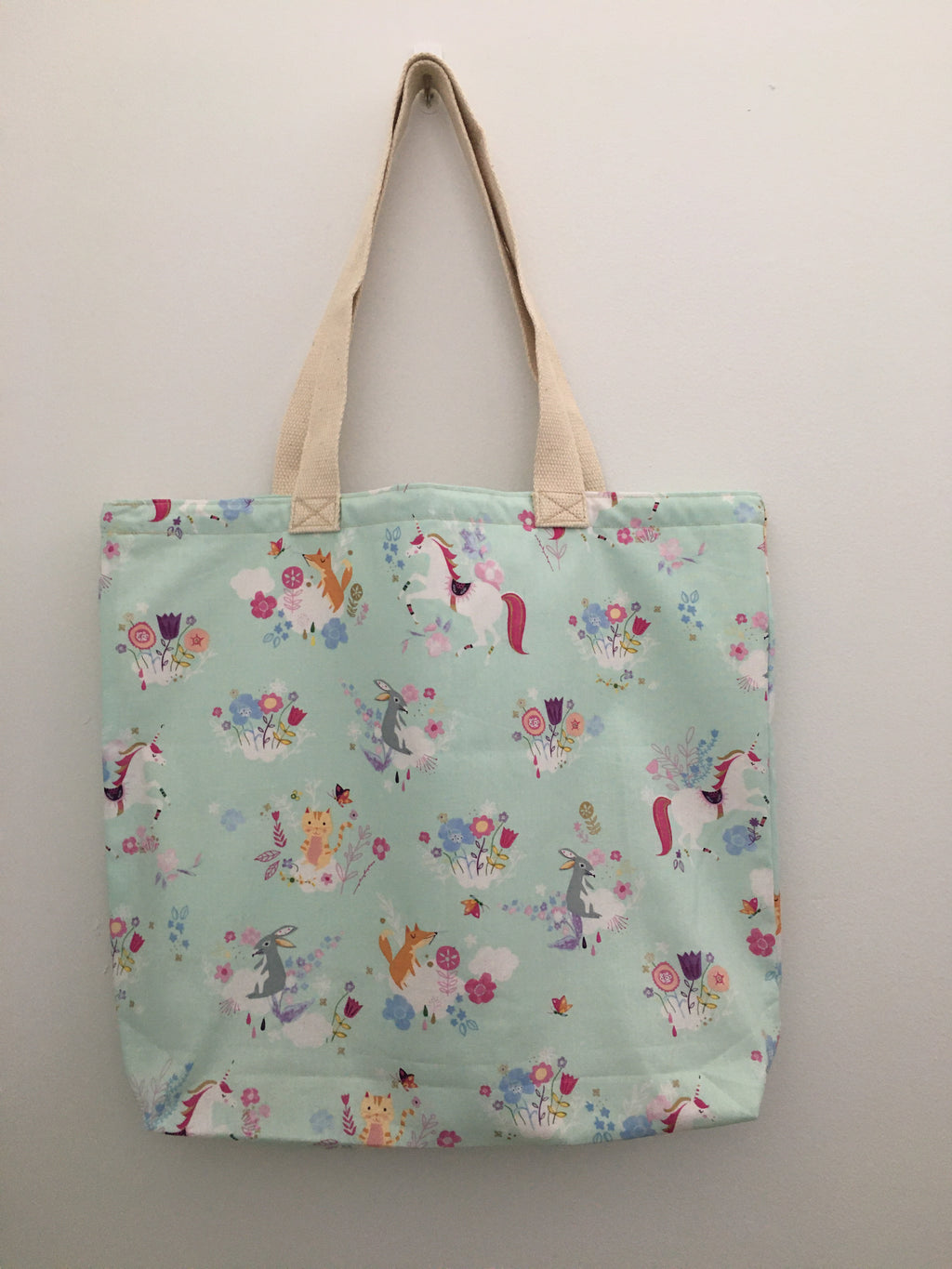 This is a magical world with unicorns and their forest friends. This mint-green handmade tote has white unicorns accompanied by foxes, rabbits, yellow cats, butterflies, and pink and blue flowers. All the fabric; from the muslin lining to the trim and the thread are 100% cotton. Measurements are around 16in x 19in x 4in.