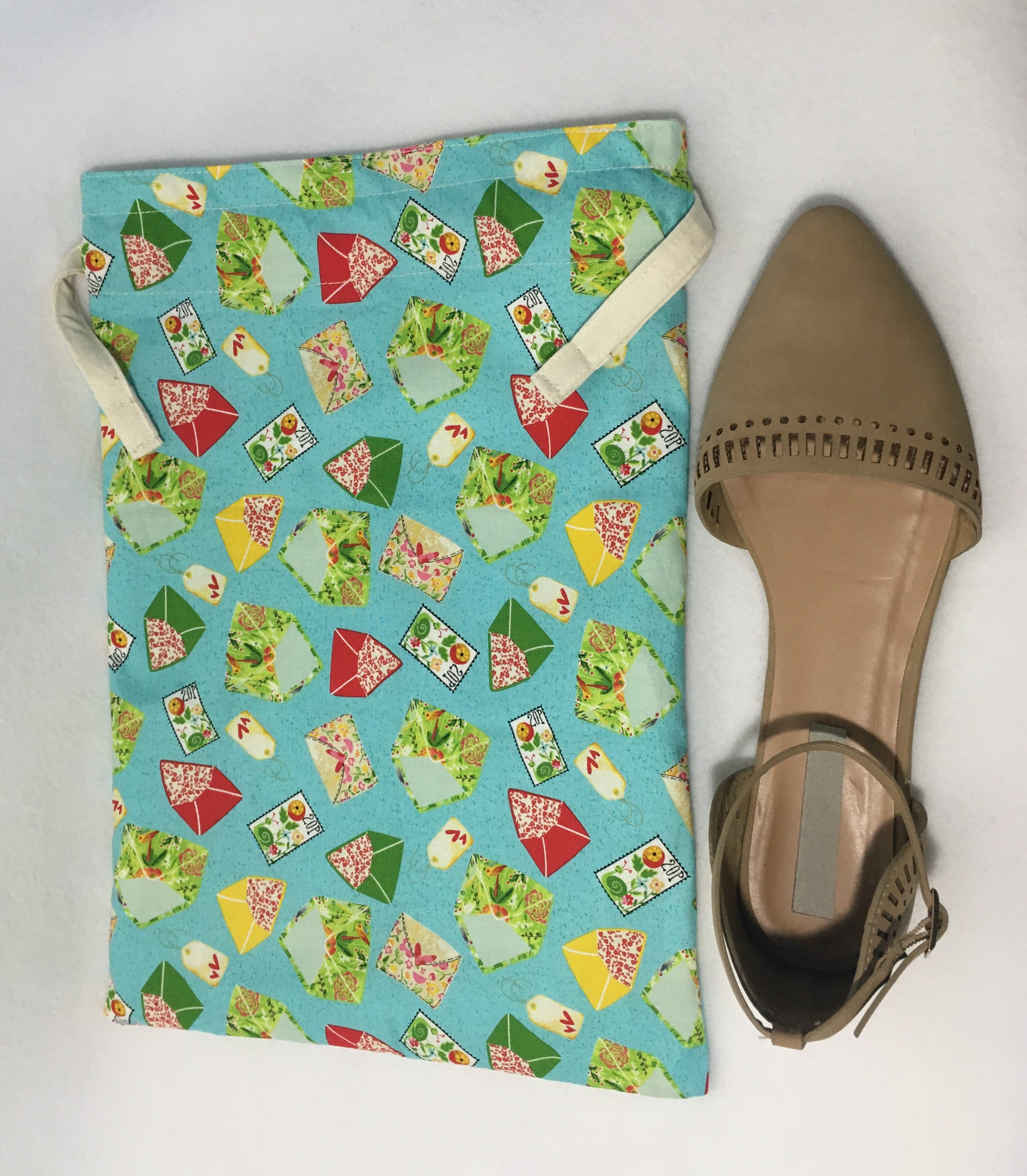 Pretty envelopes for travel! This beautiful handmade shoe / travel bag is 100% cotton and is also lined with muslin fabric. The travel bag has fancy red, green, yellow and white in a turquoise background and pull strings in the top to secure the content. This bag can be used for holding your shoes, underwear, socks, or just using it as a gift bag. Measurements are around 14in x 10in. (shoe not included)