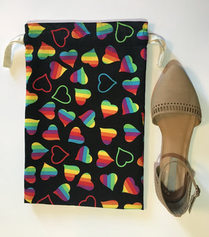 Happy Pride! This beautiful handmade shoe / travel bag is 100% cotton and is also lined with muslin fabric. The travel bag has bright rainbow hearts in a black background and pull strings in the top to secure the content. This bag can be used for holding your shoes, underwear, socks, or just using it as a gift bag. Measurements are around 14in x 10in. (shoe not included)