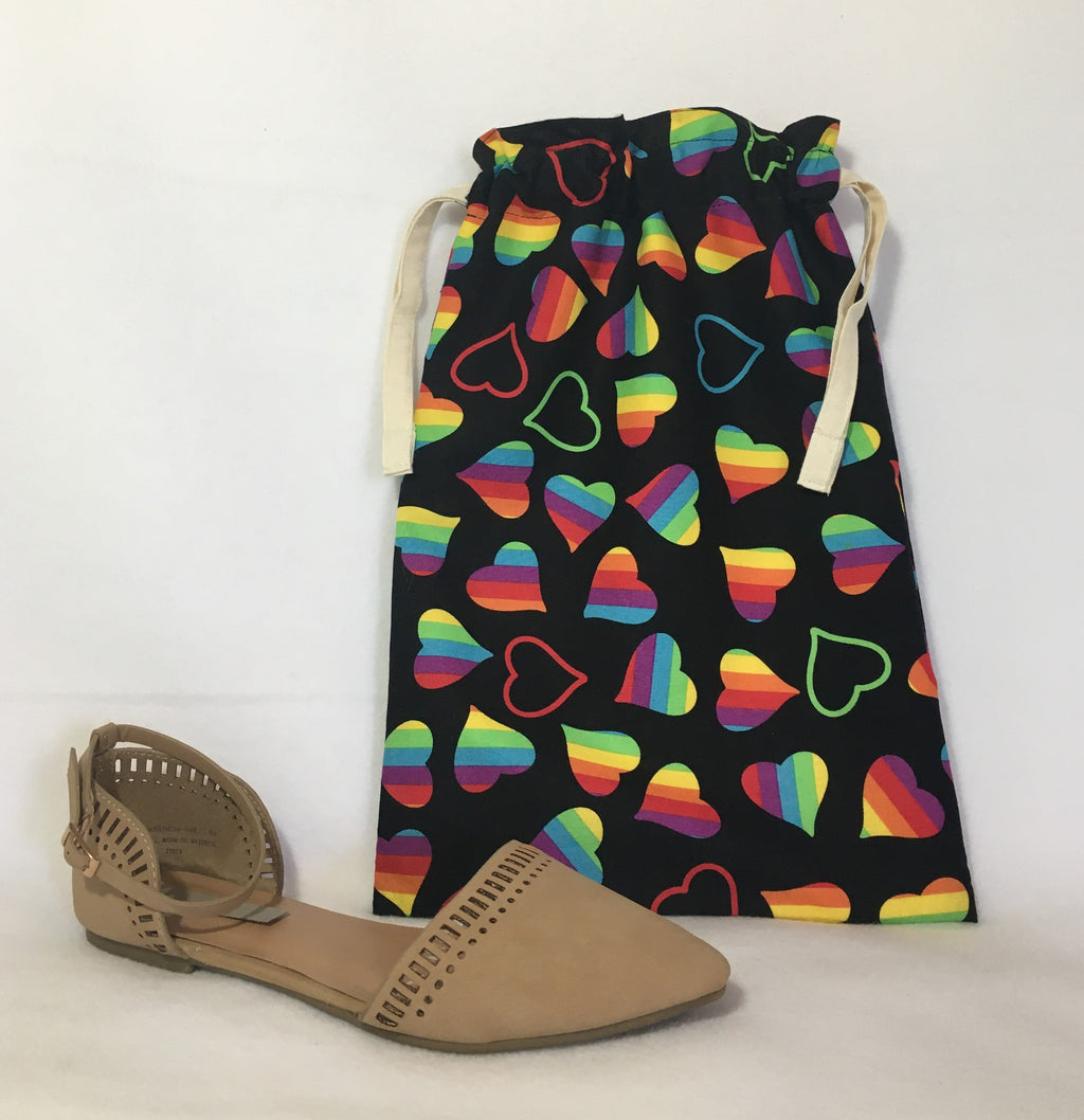 Happy Pride! This beautiful handmade shoe / travel bag is 100% cotton and is also lined with muslin fabric. The travel bag has bright rainbow hearts in a black background and pull strings in the top to secure the content. This bag can be used for holding your shoes, underwear, socks, or just using it as a gift bag. Measurements are around 14in x 10in. (shoe not included)